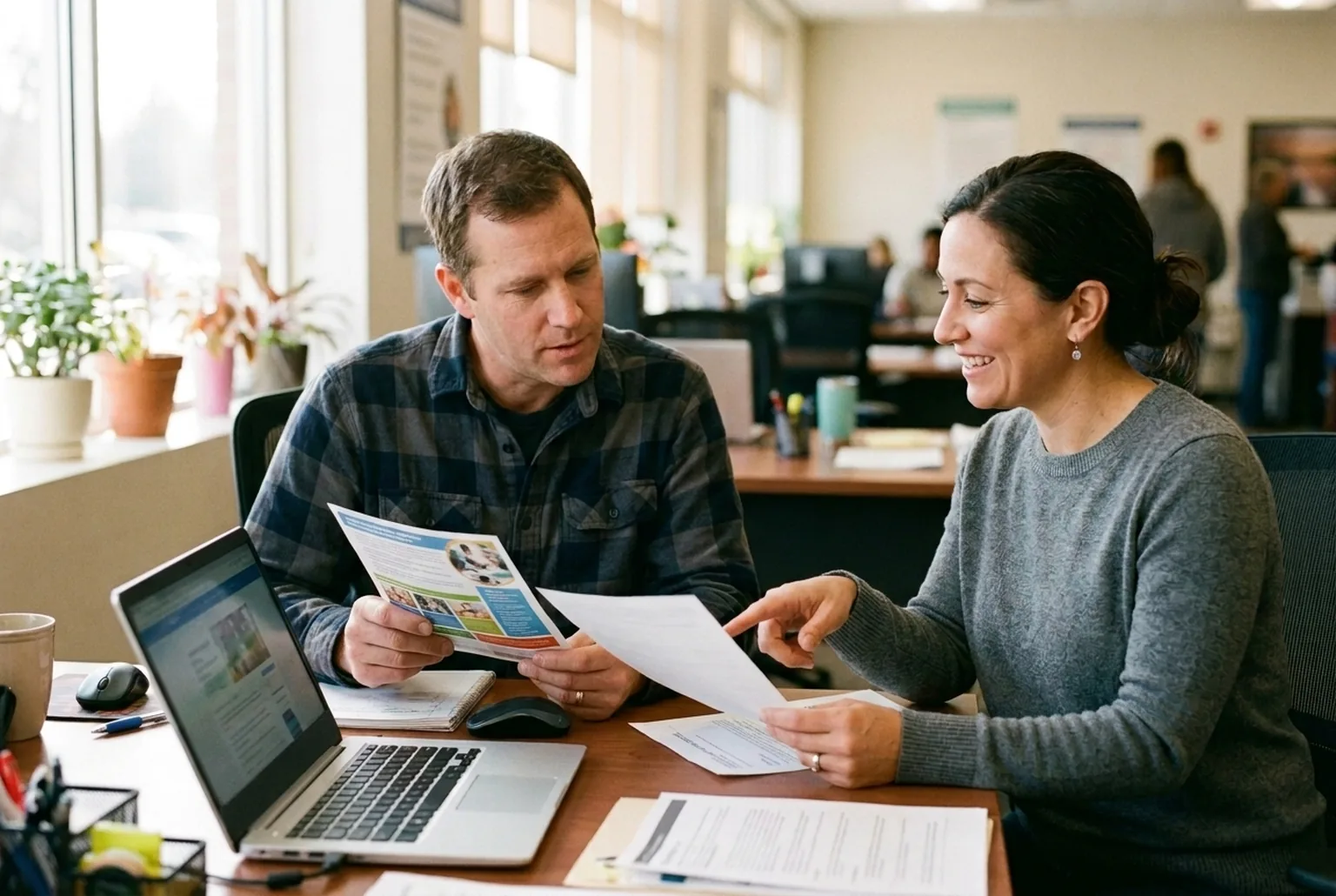 An adult career changer reviewing training program options with a workforce counselor at an American Job Center desk